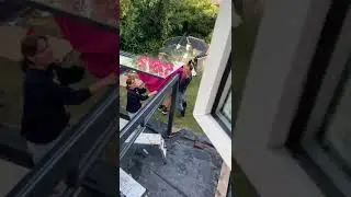 lifting 3m long glass panel into place for #Gumax veranda from #tuinmaximaal