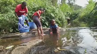Africa village life//village wife doing laundry in the river.